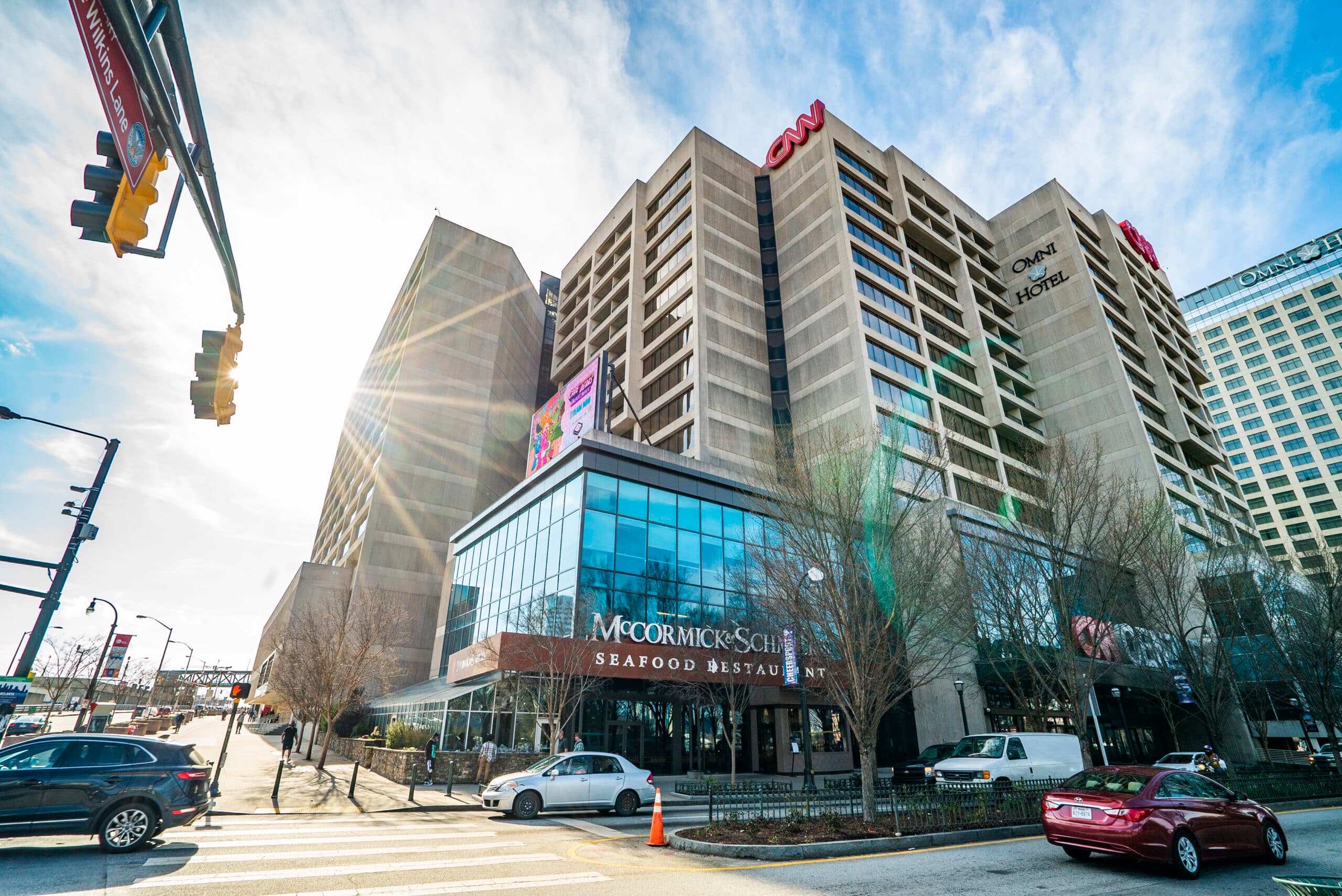 Street-level architectural photograph of the former CNN Center, with its concrete facade, glass frontage, and CNN rooftop sign